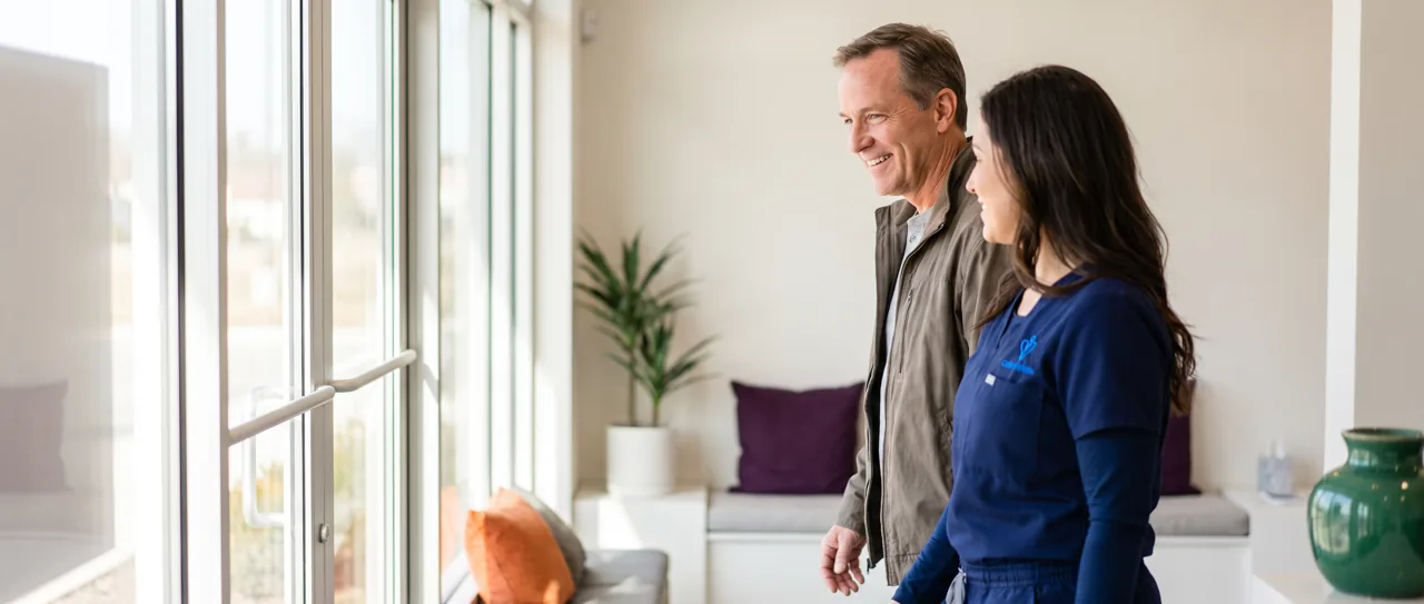 Nurse practitioner walking a smiling patient to the door of a peptide clinic