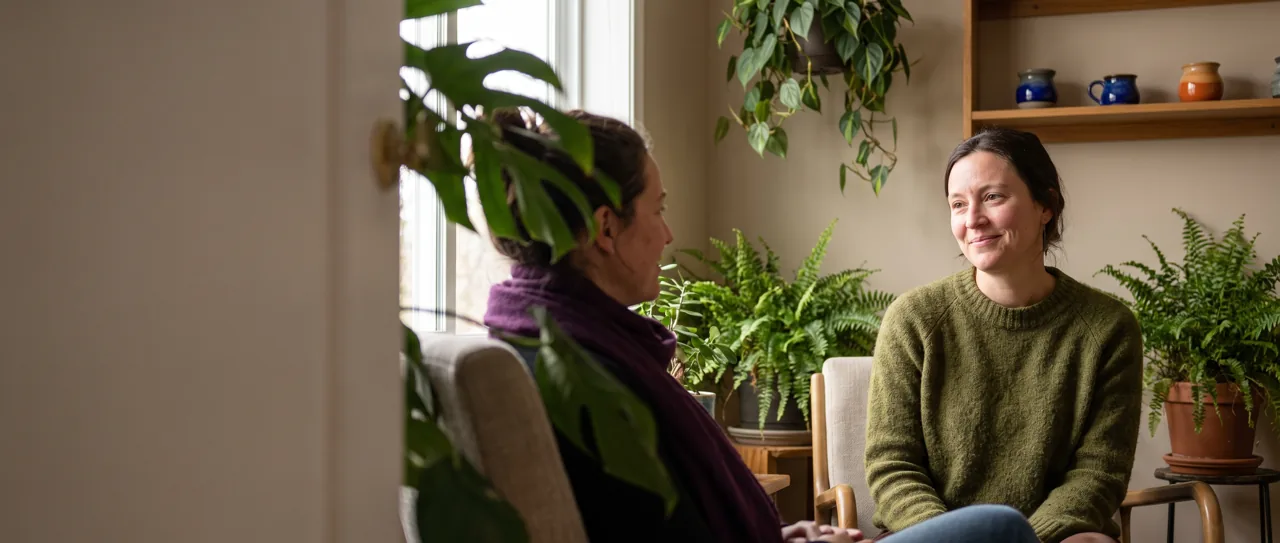 Psilocybin facilitator smiling with a client in a calm session room